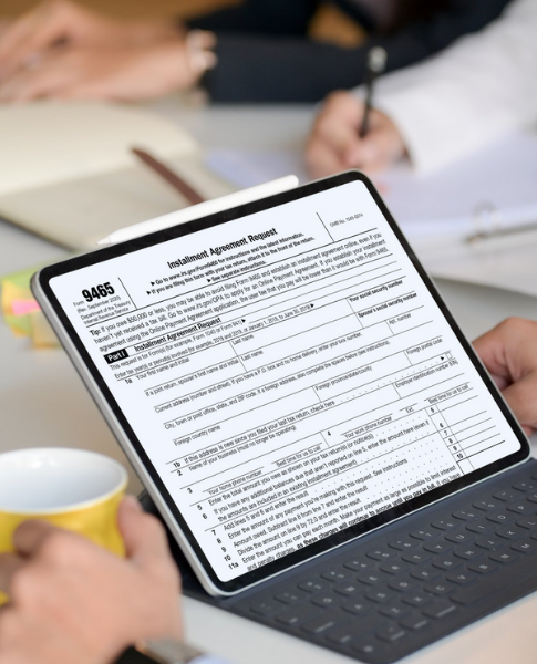 Man holding laptop that shows IRS Installment Plan form.